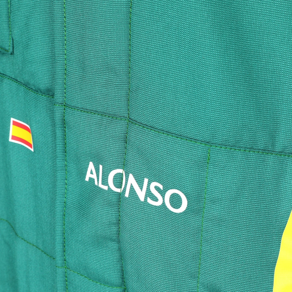  Alonso name and Spanish flag detail on the green 2026 Aston Martin F1 race suit – Active Racegear.